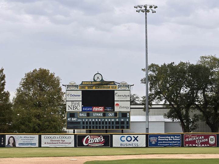 A ballpark scoreboard showing balls, strikes and outs above the outfield fence.