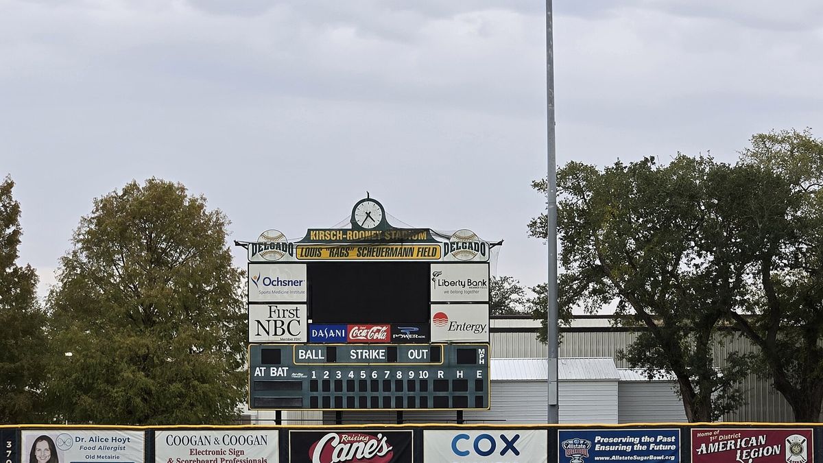 A ballpark scoreboard showing balls, strikes and outs above the outfield fence.